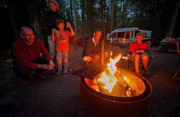 Family roasting smore over campfire