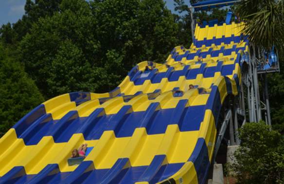 People sliding on mats down the Riptide Run