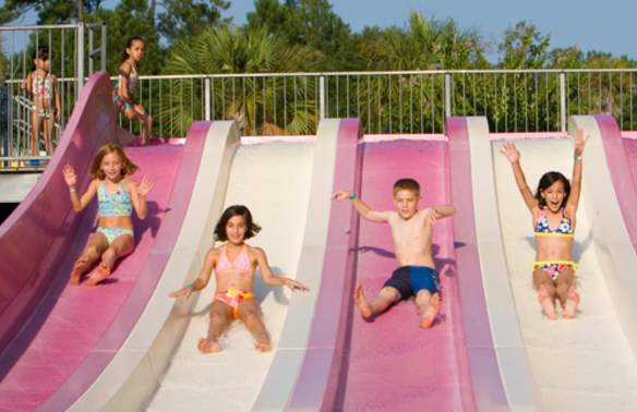 Children sliding down slides in Otter Bay