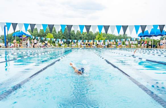 Young girl swimming at a swim meet.