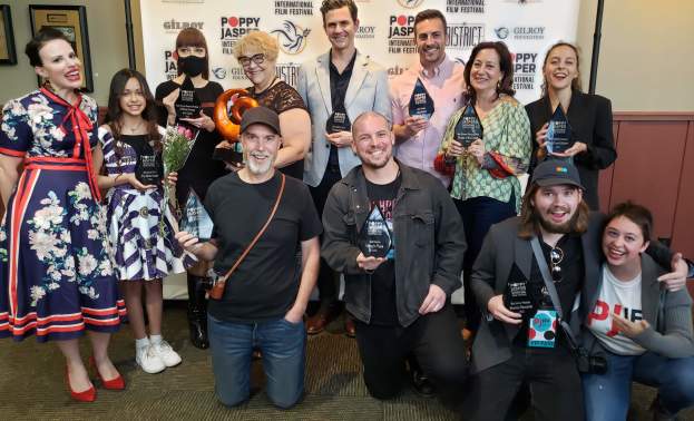 A group of 12 filmmakers present their awards in a group photo at the Poppy Jasper International Film Festival Filmmakers Awards Ceremony