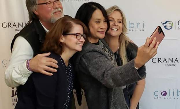 Four people pose for a selfie on the PJIFF Poppy Bash red carpet