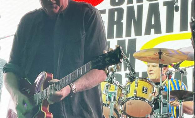 Man Plays guitar with band on stage at an exclusive indoor celebration