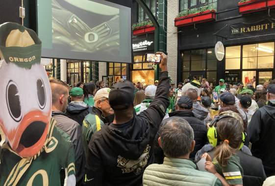 A crowd of Duck fans gather in Market Alley under a big screen.