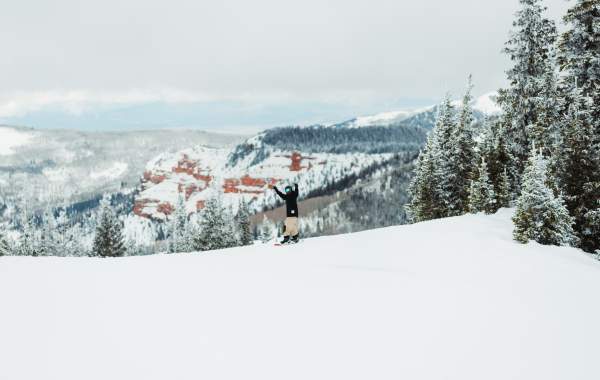 Snowboarding at Brian Head Resort with beautiful red rock in the background.