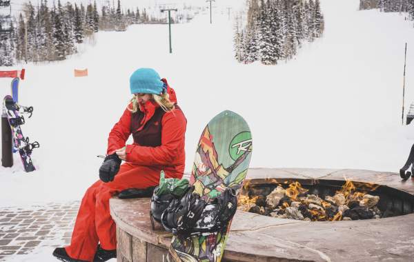 snowboarder sitting next to the fire at brian head resort