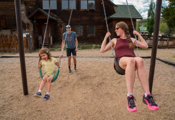 Family swinging on Grand Lake playground