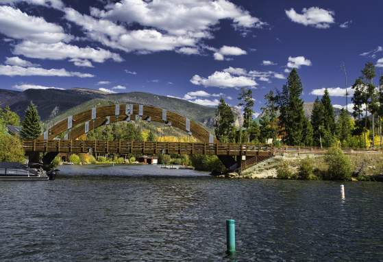 Bright blue sky over Shadow Mountain Reservoir with wooden arches of Rainbow Bridge