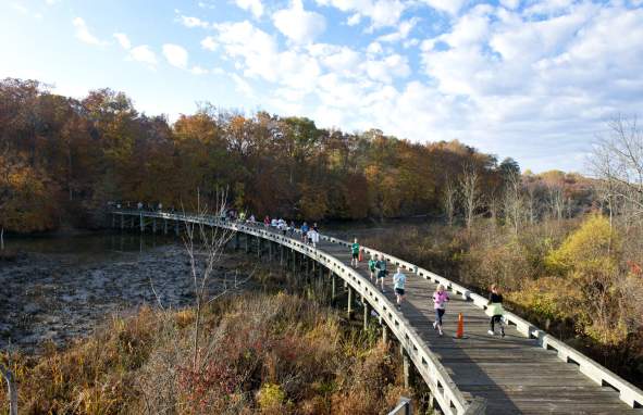 Runners cross a wooden bridge over Jug Bay in Prince George's County