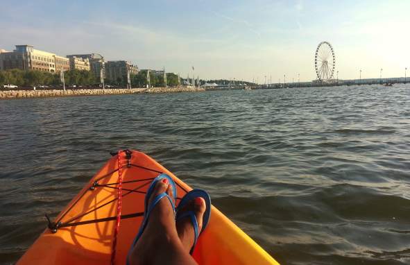 Person sitting in Kayak looking at farris wheel