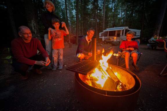 Family roasting smore over campfire