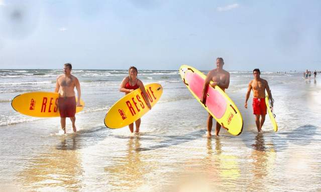 Port Aransas lifeguards hold surfboards in the surf