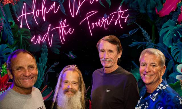 Four band members smile at the camera.
