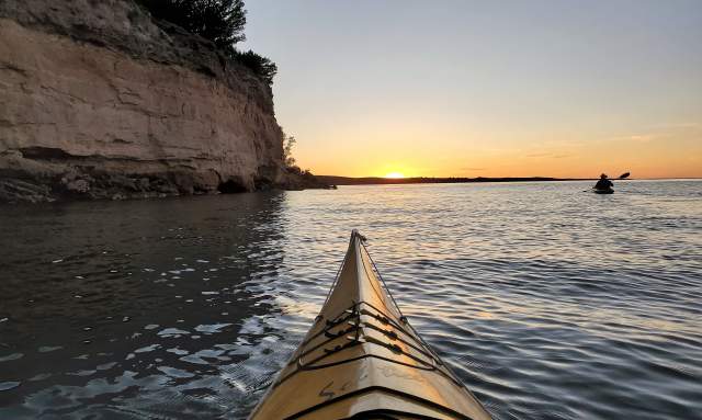 kayak at sunset near cliff
