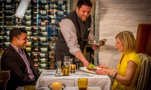 Dinner being served by waiter for the couple dining