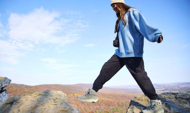 A woman walking across rocks on an overlook