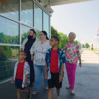 Multi-Generational family visiting Fayetteville's Veterans' Park with the ASOM in the background