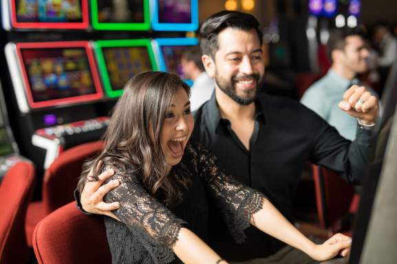 Couple playing slots at casino