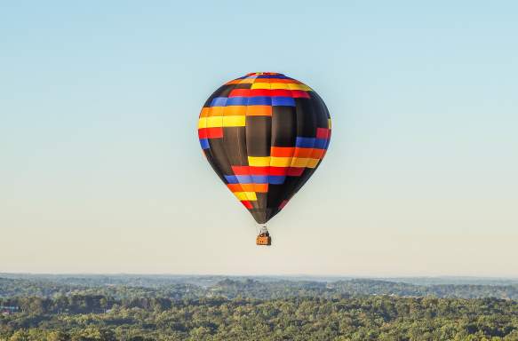 A hot air balloon floating over Bloomington's countryside