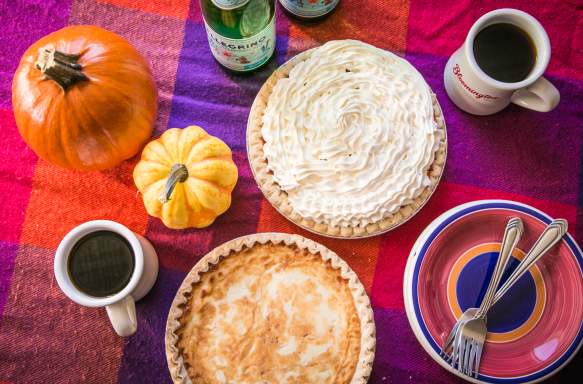 Pumpkin pie with whipped cream on an autumn themed table