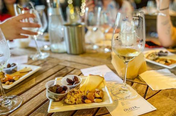 A table of women enjoying wine and charcuterie plates at Oliver Winery