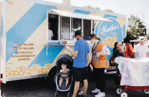 A white and blue food truck with mini pancakes on it called Martha's Minis