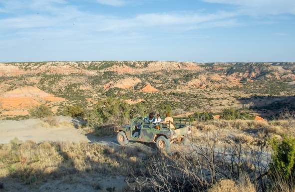 Group of friends in humvee overlooking palo duro canyon