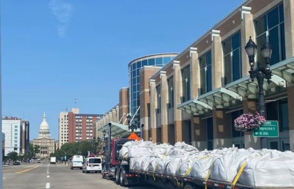 A flatbed truck with horseshoe pitching clay parked in front of the Lansing Center