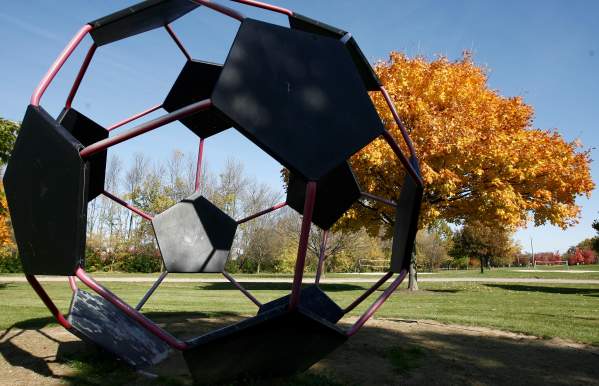 Giant metal soccer bar art installation in a fall colored park.