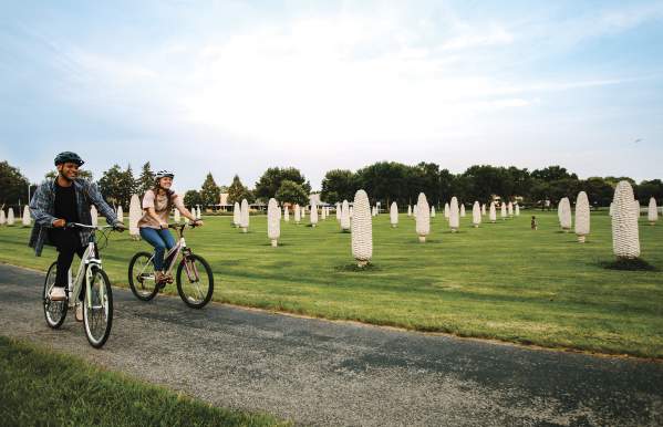 Two friends biking past the field of corn