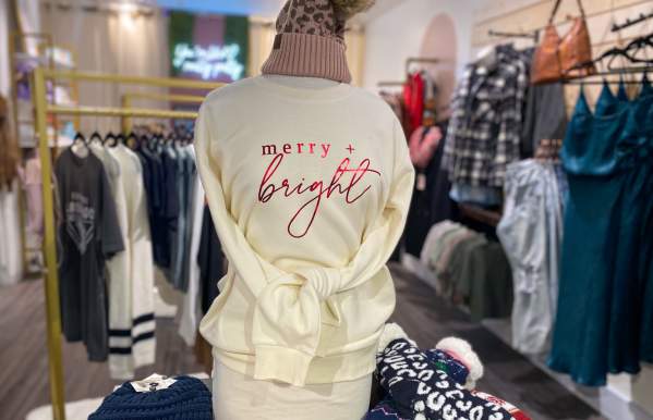 Mannequin with a sweatshirt from Flourish in Bridge Park that reads "Merry and Bright"