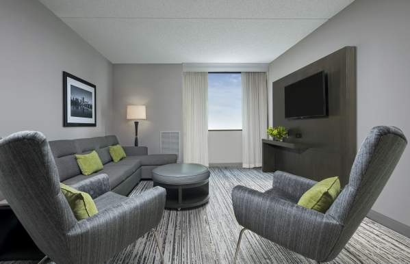 Marriott NW living room with couches, chairs, tables and flat screen.