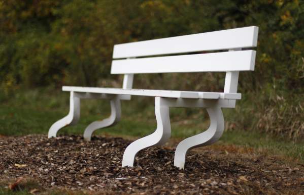 A white bench with four curved legs