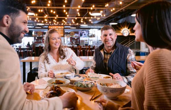Two couples enjoying food at a community table in North Market Bridge Park