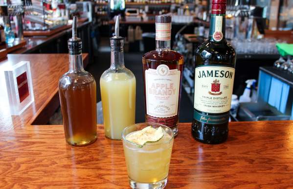 The Dubliner Celtic Cocktail from Market Bar in from of ingredients bottles
