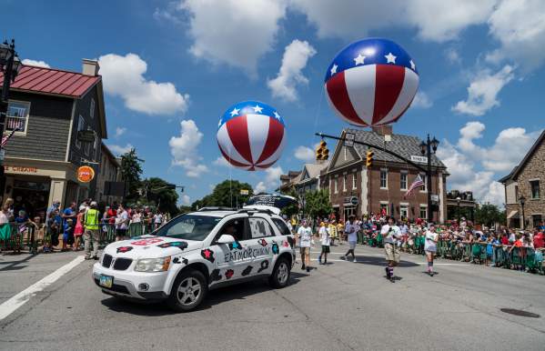 Red white and blue balloons floating behind a car and parade float in Historic Dublin.