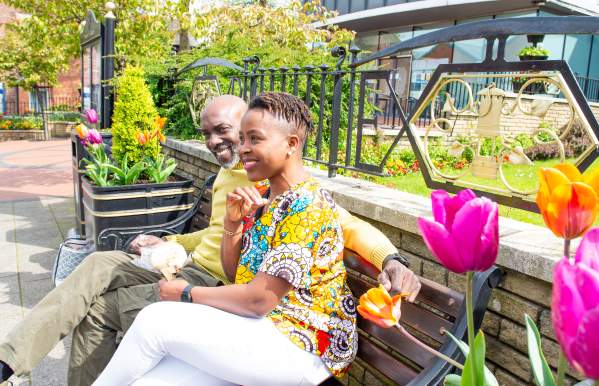 couple sit on bench by floral display diversity