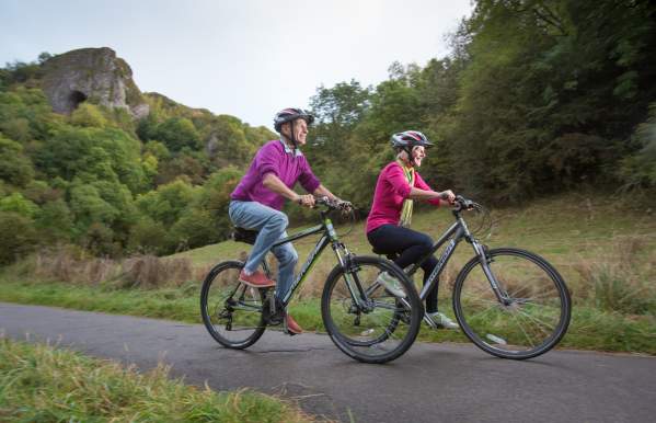 couple on a bike ride with Thor's Cave in background
