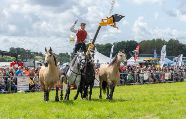 man with four horses acrobatic horse riding display in the main arena at Leek Show