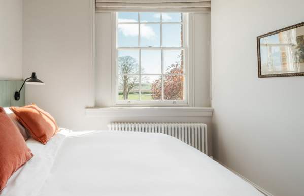 Indoor shot of double bed in bedroom with picturesque view through window taken at Constantine House