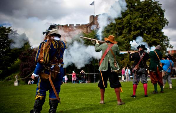 People firing musket rifles in the grounds of Tamworth Castle re-enacting a historical event