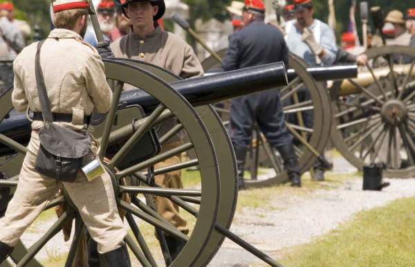 a soldier operating a cannon at a battle reenactment