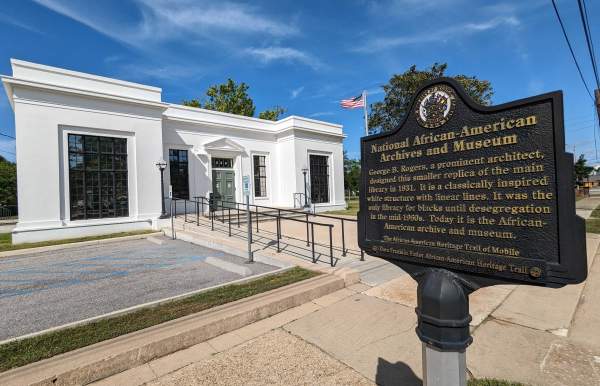 white building with an iron sign: National African American Archives and Museum