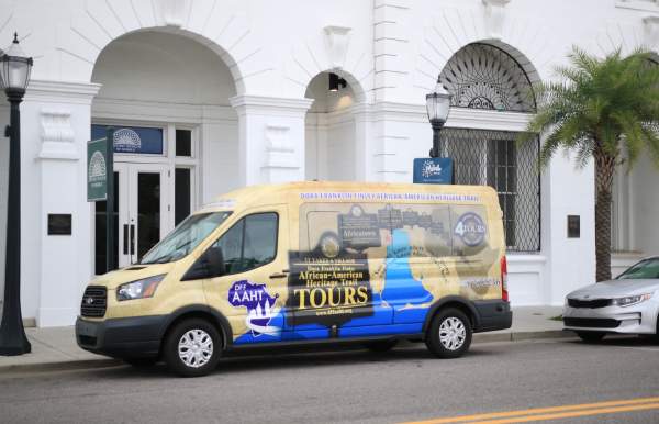 colorful passenger van parked in front of white building