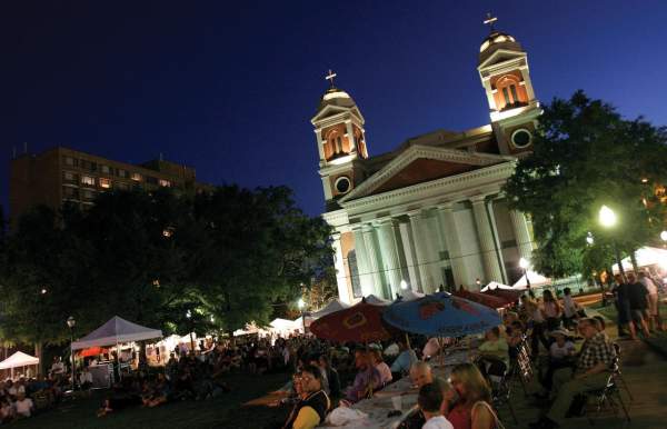 An art festival at night in front of a cathedral