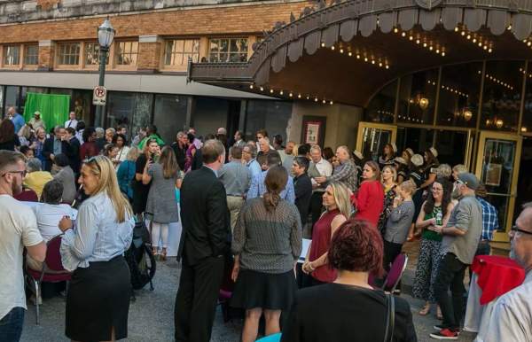 Community partners crowd gathered together networking outside in Mobile, AL