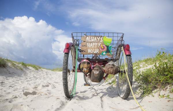 Old, three wheel bicycle parked on the beach