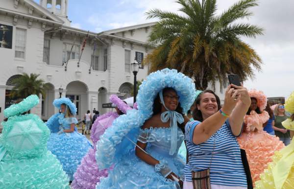 lady posing with an Azalea trail maid in front of the History Museum