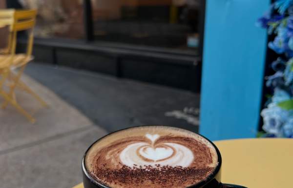 Mug of coffee sitting on a patio table outside