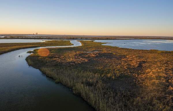 water and grass land masses at sunset